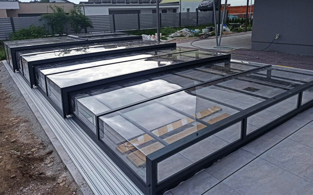 Zadaszenie basenu z przezroczystymi panelami w nowoczesnym ogrodzie.