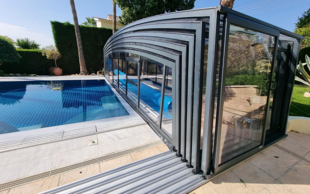 Nowoczesna zabudowa basenu z przezroczystymi panelami w ogrodzie.